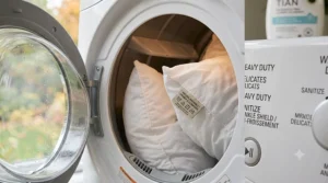 A fresh, clean pillow being tumbled in a dryer to regain fluffiness.