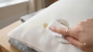 Low maintenance pillow icon emphasizing hypoallergenic, dust-resistant fabric. / Icône d'oreiller facile d'entretien soulignant un tissu hypoallergénique.