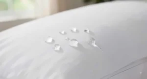 Water beading on the surface of a waterproof pillow protector demonstrating liquid-proof technology.