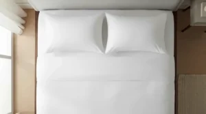 Demonstrating the dimensions of a medium pillow set queen size on a master bed frame.